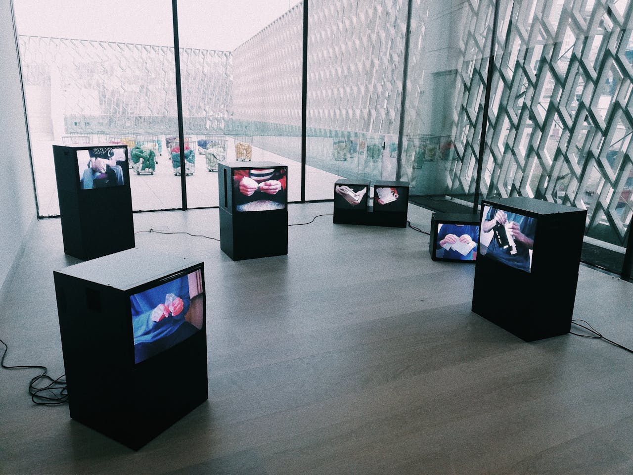 Explore a modern art exhibit with multiple screens displaying digital art in a sleek museum setting.